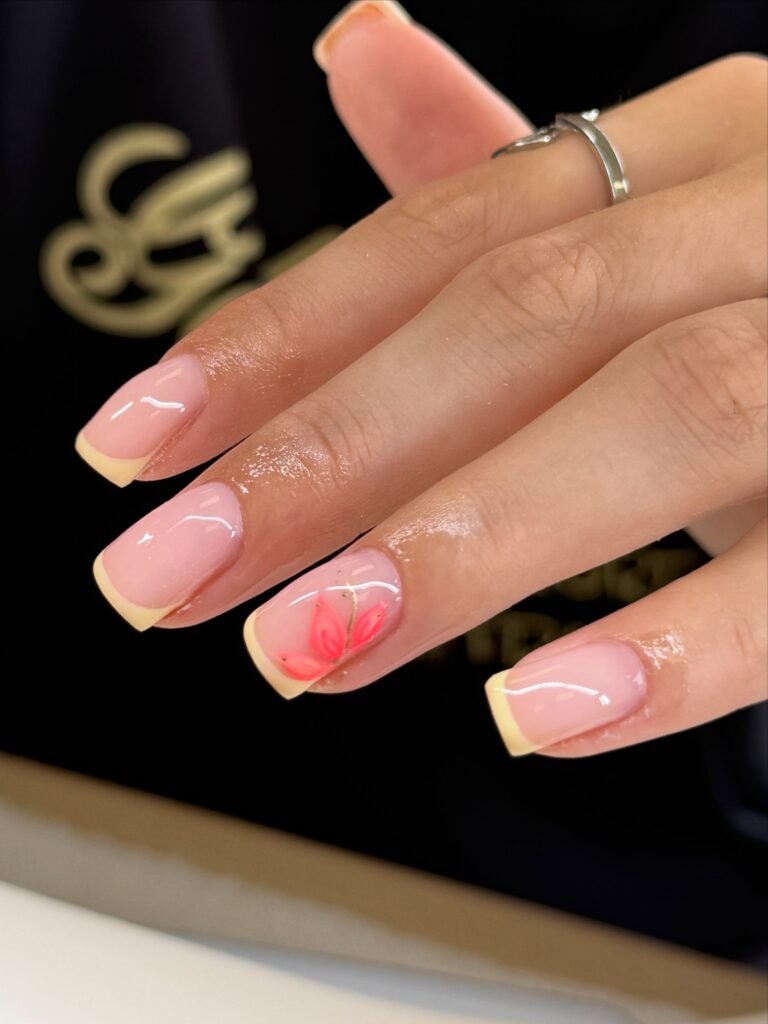 Pastel Yellow French Tips with a Flower Accent